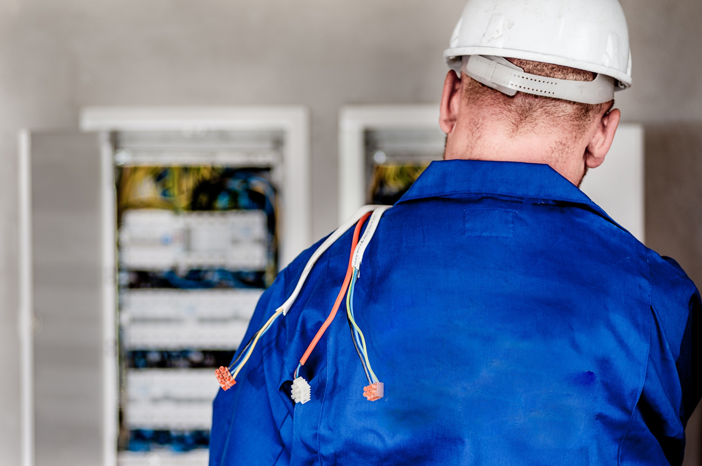Technician performing preventive maintenance on electrical equipment